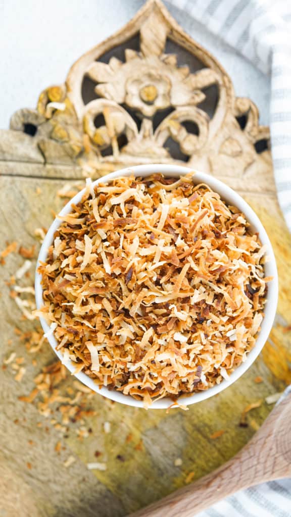 Air fryer basket with coconut flakes toasting