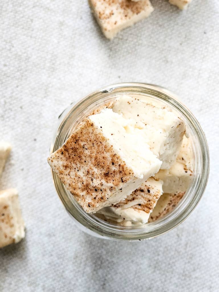 "Slicing the chilled eggnog fudge into pieces, with a focus on the texture and consistency."