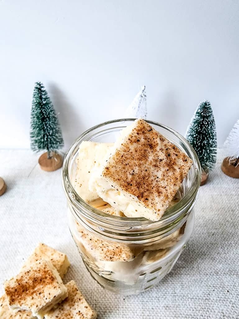 "A bowl of creamy, smooth eggnog fudge with a festive garnish, ready to be served."