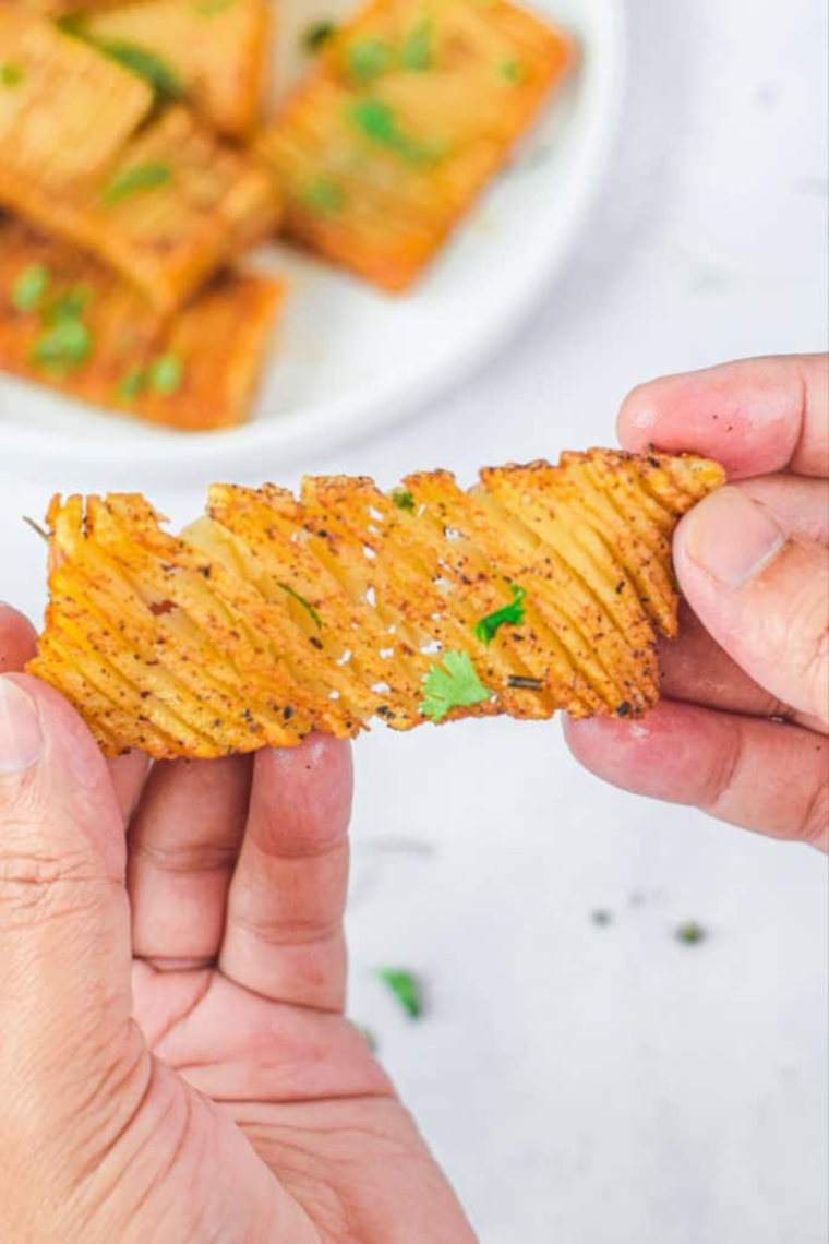 "Serving air fryer accordion potatoes with garnishes and seasoning."