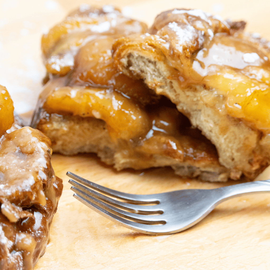"Air Fryer Bananas Foster French Toast topped with caramelized bananas and a drizzle of syrup."
