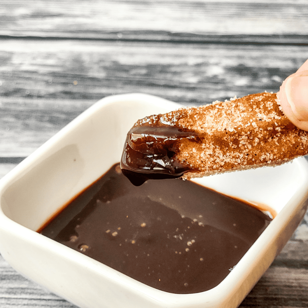 Golden and crispy Disneyland copycat churros coated in cinnamon sugar, ready to enjoy with your favorite dipping sauce.