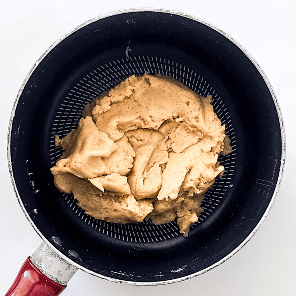 "Transfer churro dough to a bowl, add eggs one at a time, stir to combine. Heat vegetable oil to 350°F in a frying pan and fill a piping bag with the dough using a large star tip.