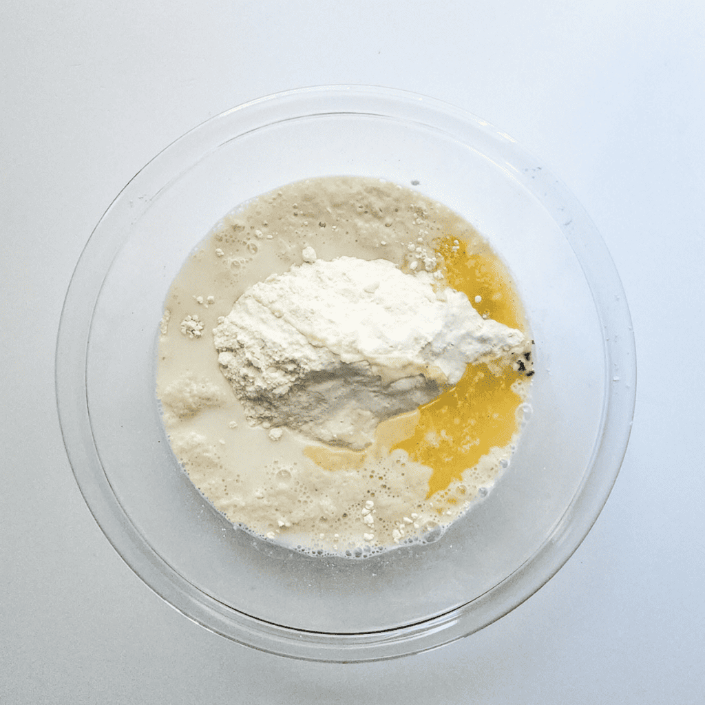Image of mixing bowl with yeast, sugar, and warm milk being combined to create the dough base for Domino's Parmesan Bites.