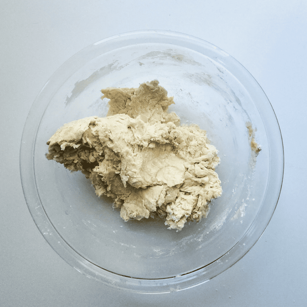 Image of hands kneading dough on a floured surface for Domino's Parmesan Bites, showing the dough becoming smooth and elastic.