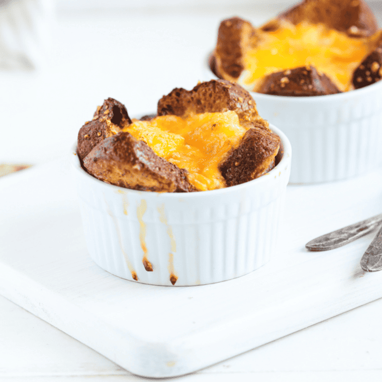 Air fryer French toast mug cup topped with syrup and powdered sugar