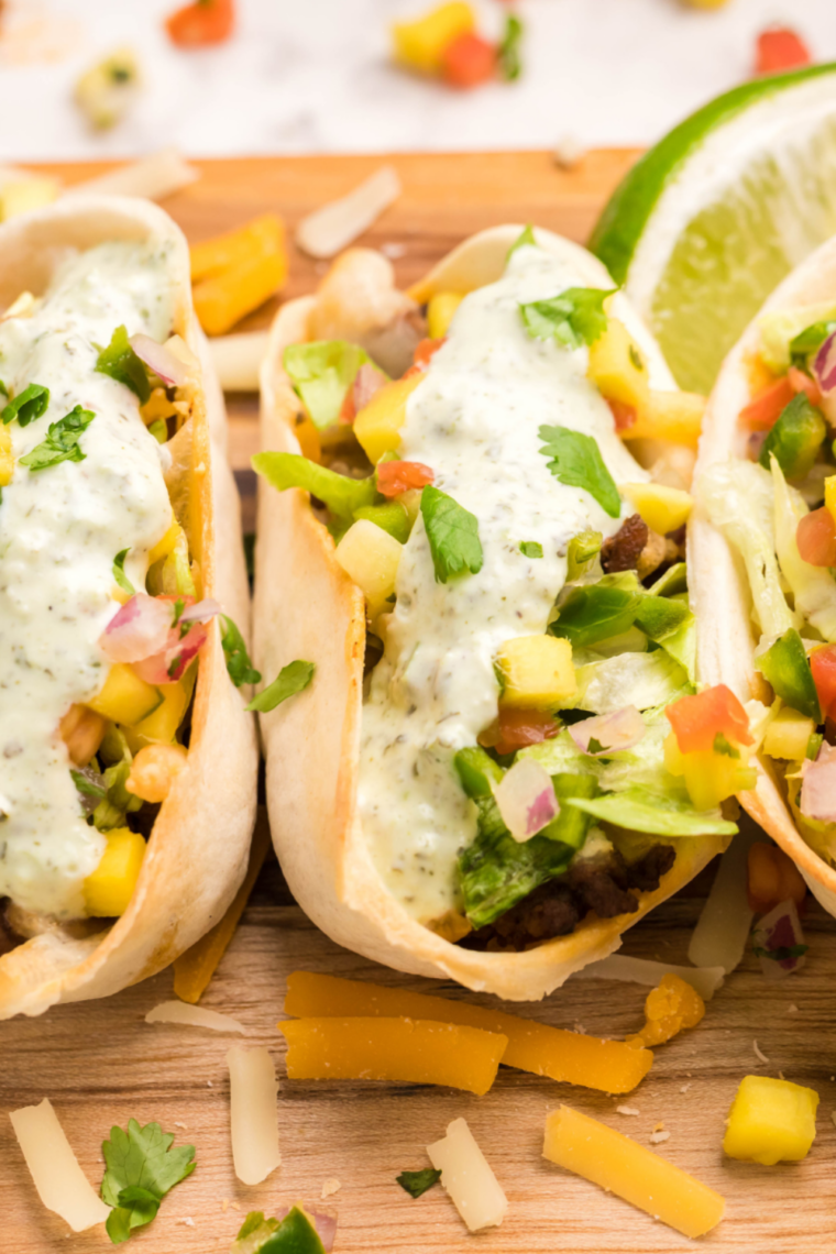 Close-up of an air fryer ground beef taco bowl with sour cream and cilantro