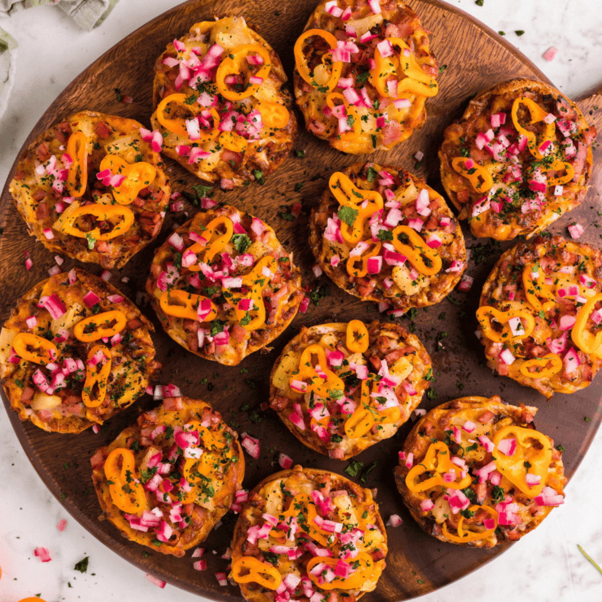 Air fryer Hawaiian pizza bagel bites topped with BBQ sauce, ham, pineapple, red onion, and fresh cilantro.