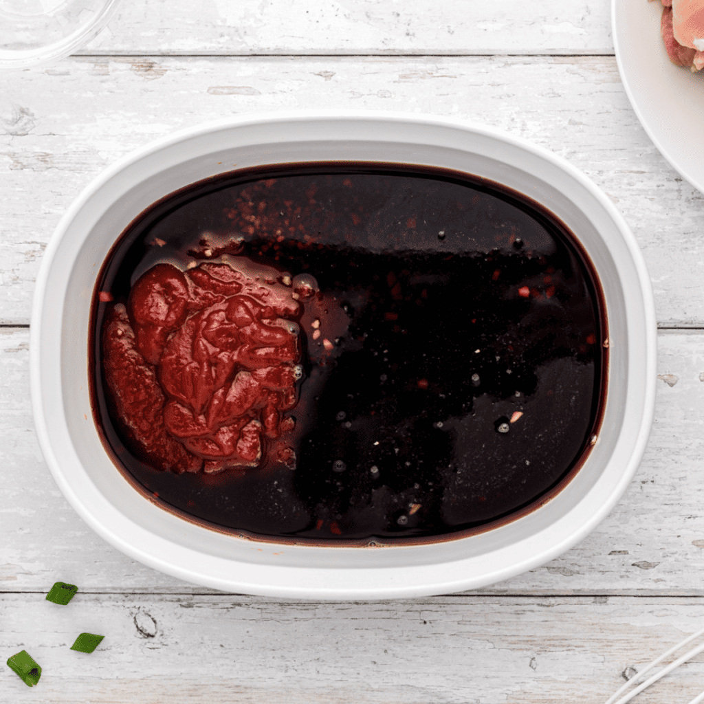 Marinating chicken in a flavorful homemade Huli Huli sauce in a bowl.