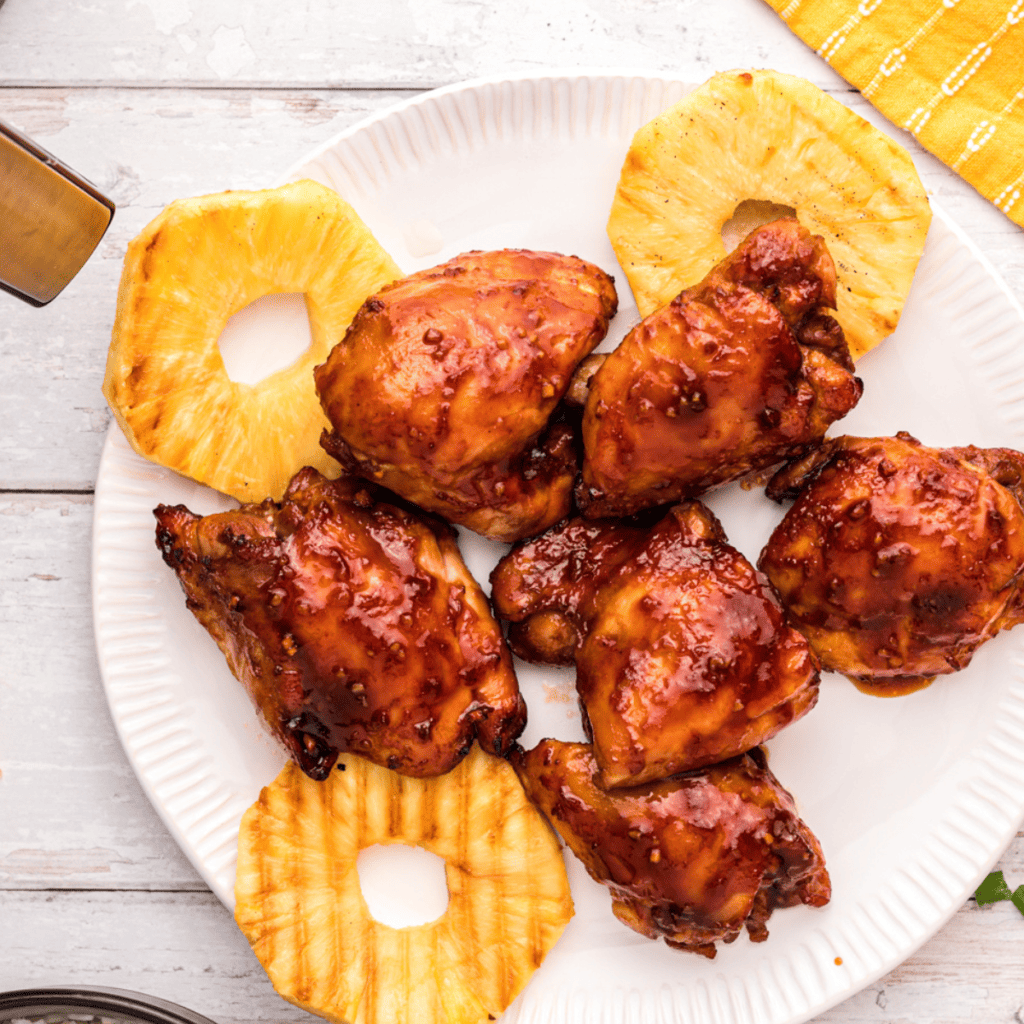 Tender Air Fryer Huli Huli Chicken with a sweet and smoky glaze, served with rice and grilled pineapple.