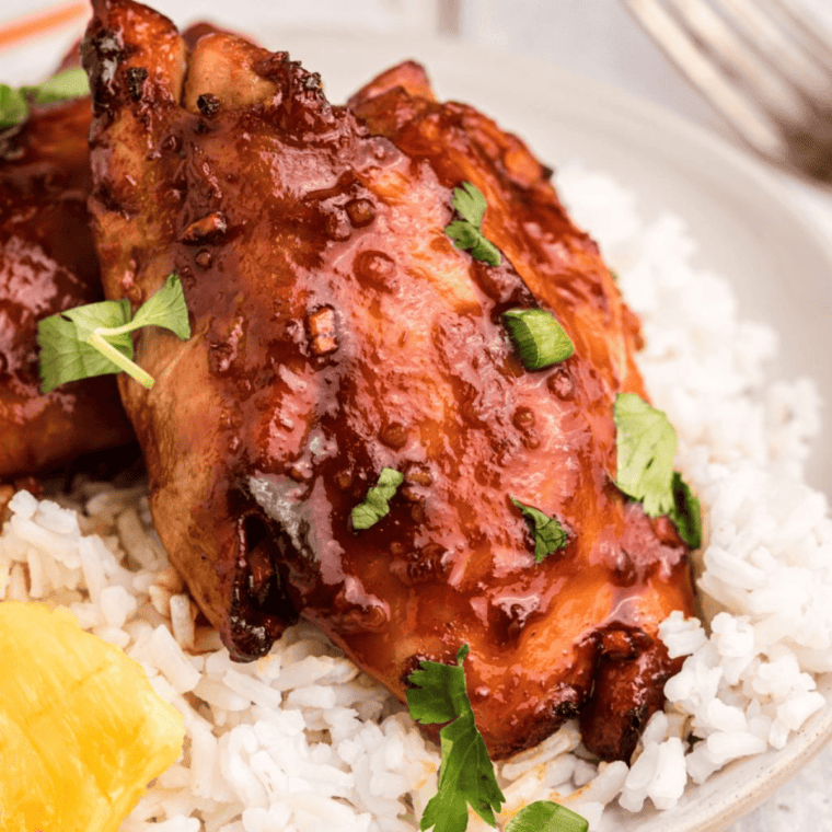 Juicy Air Fryer Huli Huli Chicken glazed with a sweet and smoky Hawaiian-style sauce, served with rice and pineapple.