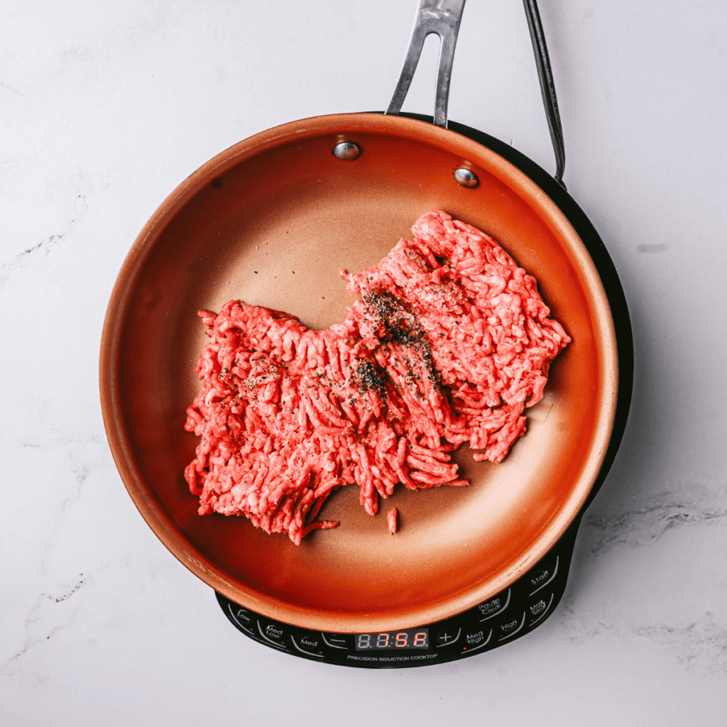 Cooking ground beef in a non-stick skillet, browned and crumbled, ready to remove from heat