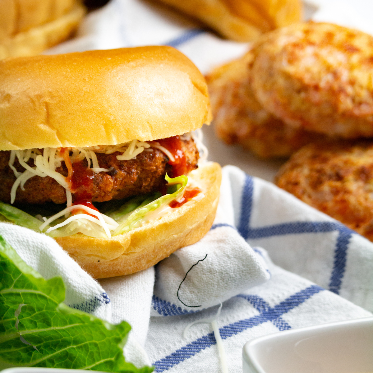 A close-up view of a golden-brown air fryer shrimp burger, highlighting its juicy interior and crispy exterior.