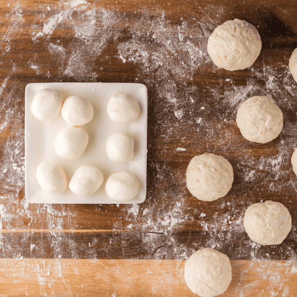 Shaping the dough into bite-sized pieces and arranging them on a parchment-lined tray