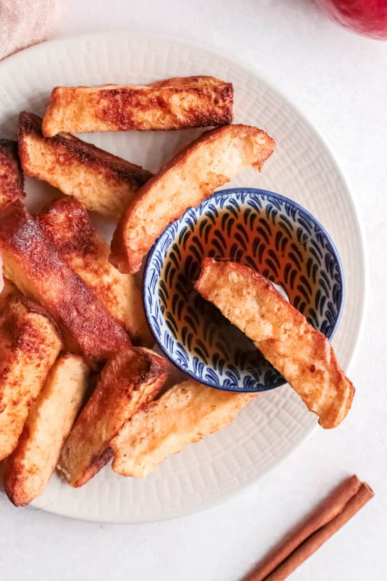 Plate of golden Air Fryer Apple French Toast Sticks with syrup.