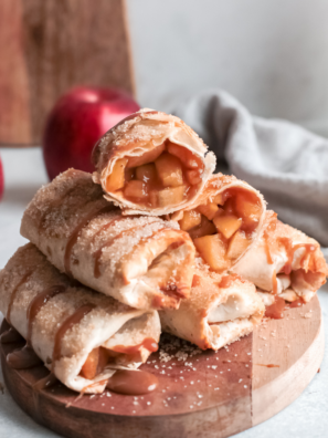 Crispy apple flautas on a white plate drizzled with salted caramel sauce