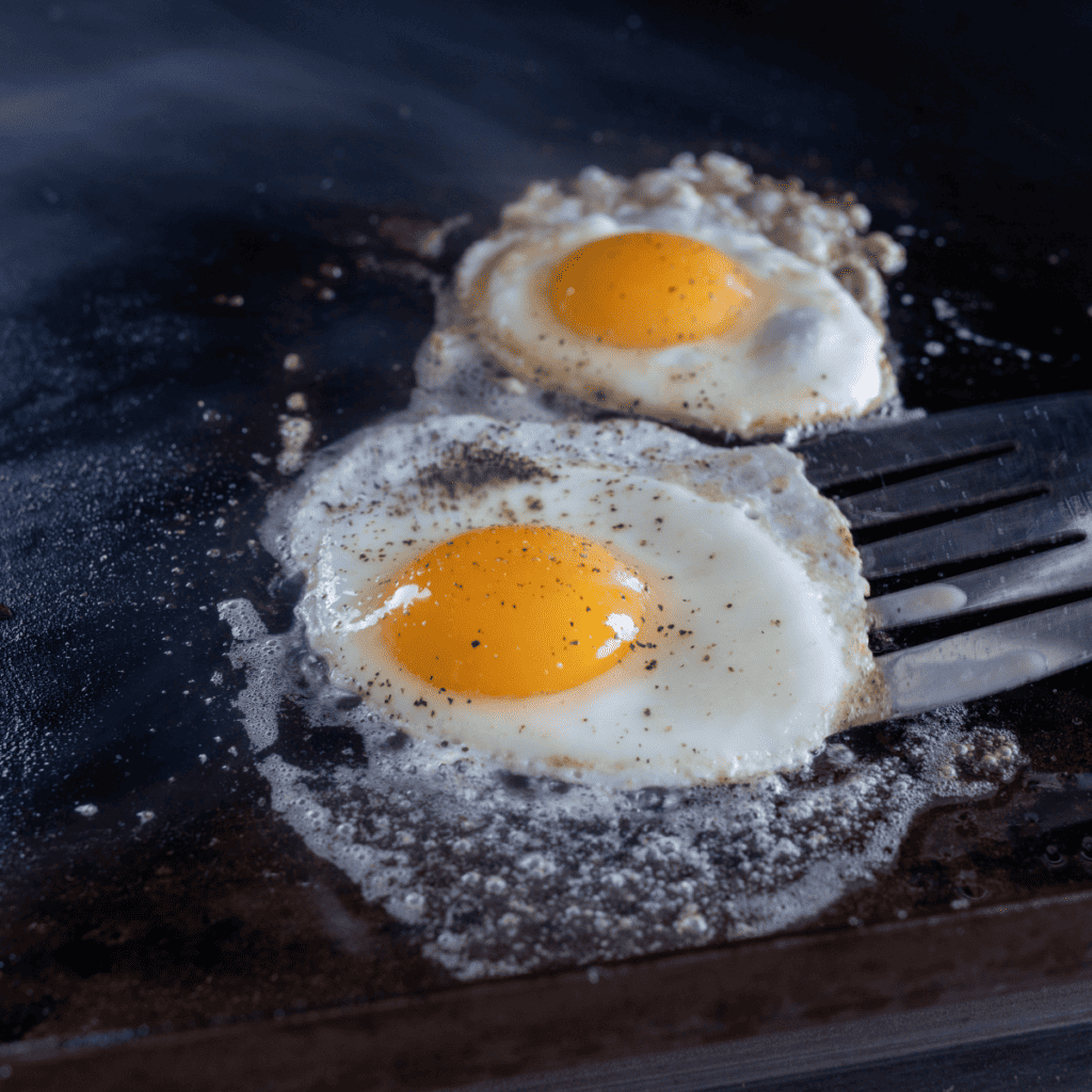 Deliciously fried eggs cooked on a Blackstone griddle with crispy edges and soft centers.