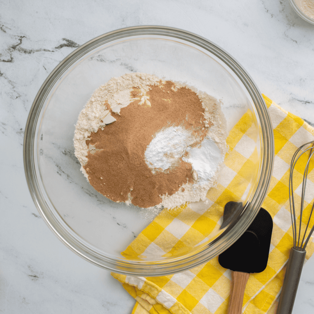 Removing excess liquid from ricotta and grated apples using a paper towel for perfect donut batter.