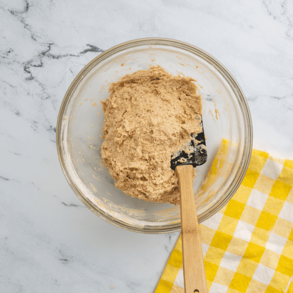 Whisking powdered sugar, Snickerdoodle seasoning, vanilla, and apple cider into a smooth glaze.