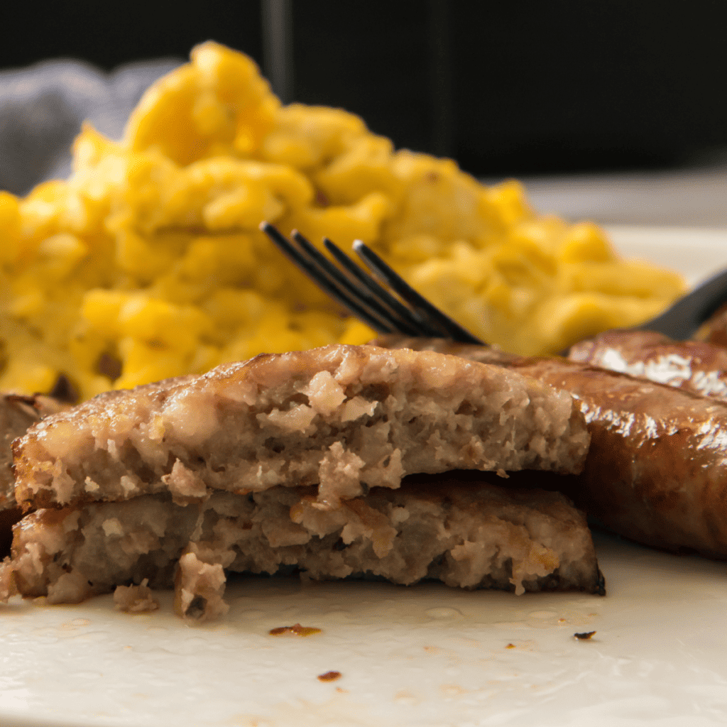 Blackstone sausage patties served with scrambled eggs for a hearty griddle breakfast.