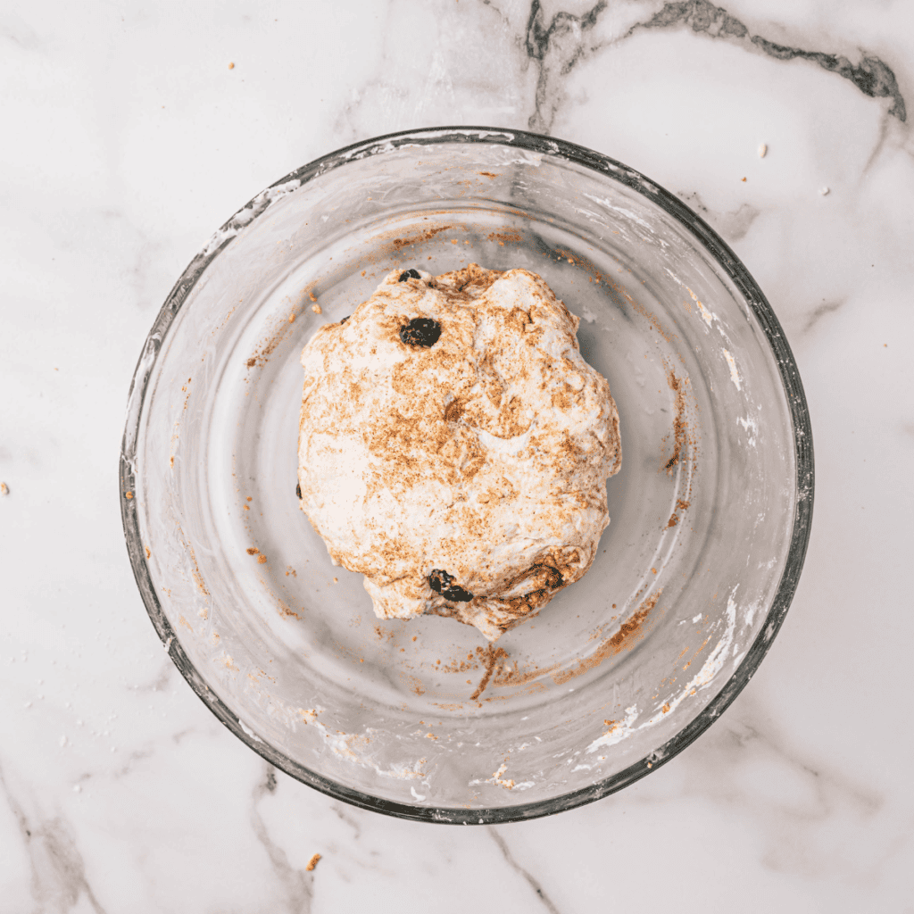 Mixing the bagel dough ingredients in a bowl to form a smooth and well-combined mixture