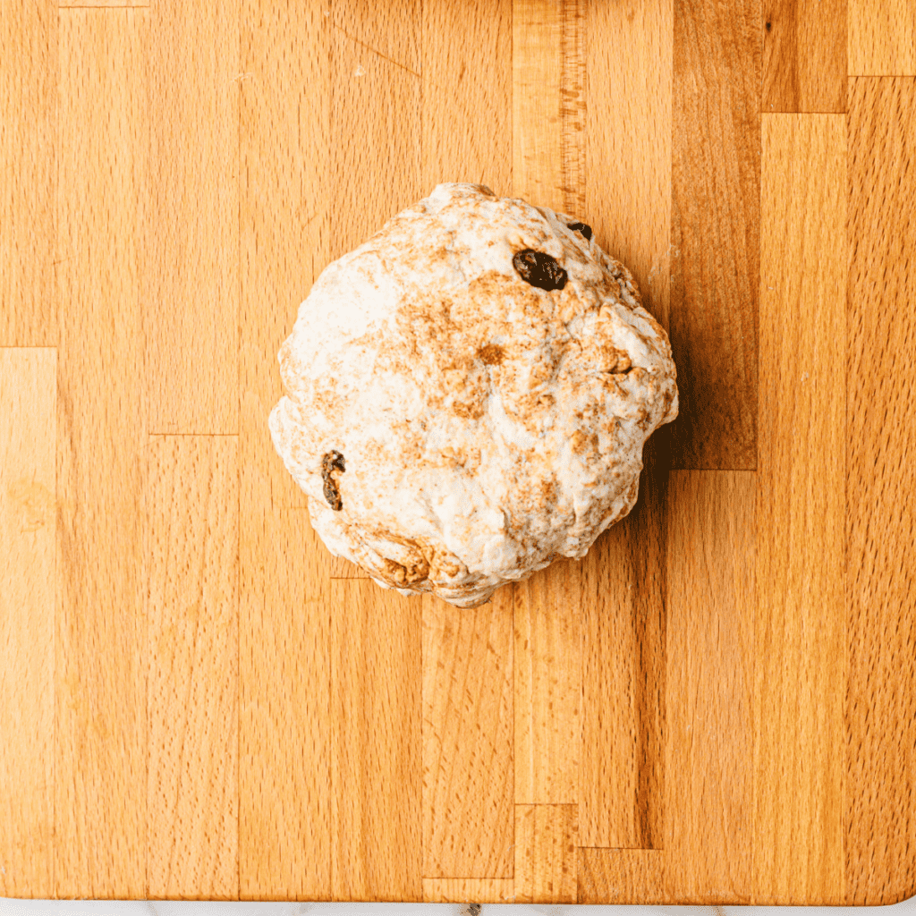 Shaping the dough into bagel forms and placing them on a parchment-lined tray