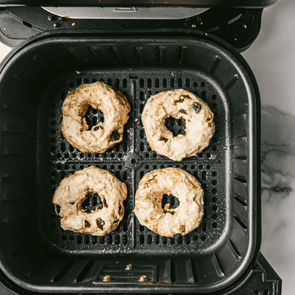 Arranging the bagels in the air fryer basket, ensuring they are spaced out for even cooking