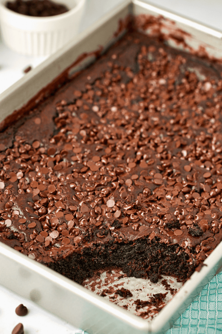 Spoon scooping warm chocolate dump cake from the pan, viewed from above