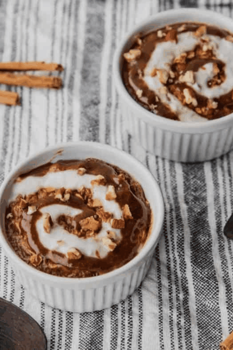 Easy Air Fryer Cinnamon Roll Baked Oatmeal topped with yogurt swirl and pecans in a white ramekin