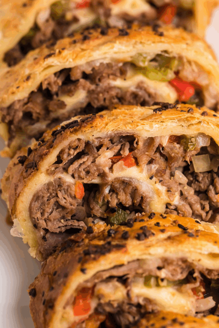 Air Fryer Italian Beef Stromboli sliced open, showing melted cheese and seasoned Italian beef inside.