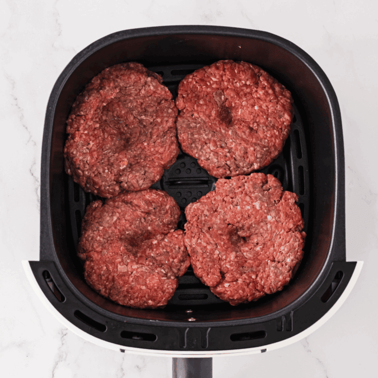 Flatten burgers in the air fryer basket.