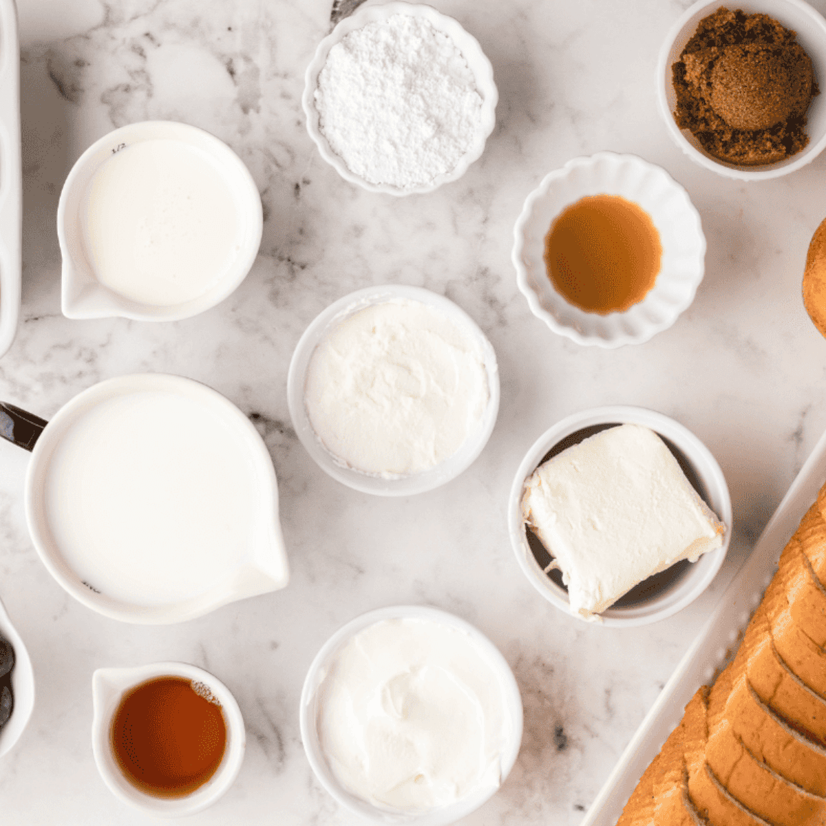 Ingredients for air fryer French toast casserole: cubed bread, eggs, milk, cream, sugar, vanilla, and cinnamon