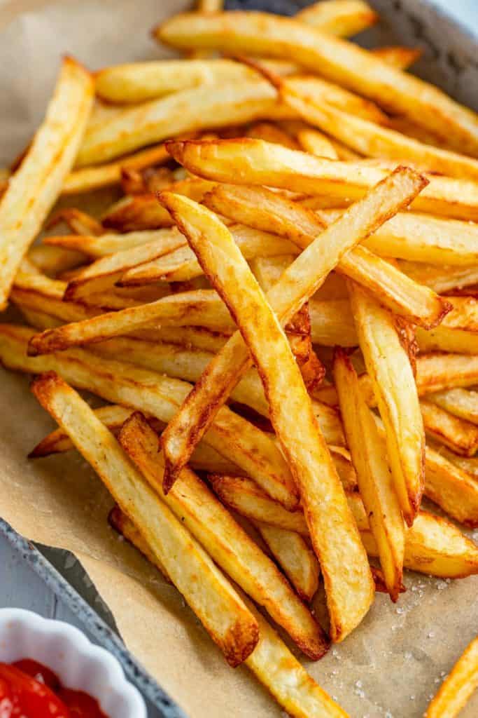 Crispy air-fried Ore Ida Golden Fries served with a small bowl of dipping sauce.