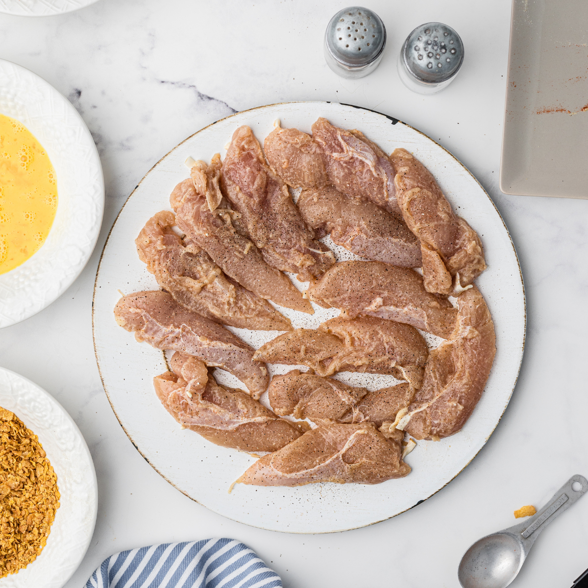 Coated chicken tenders on plate.