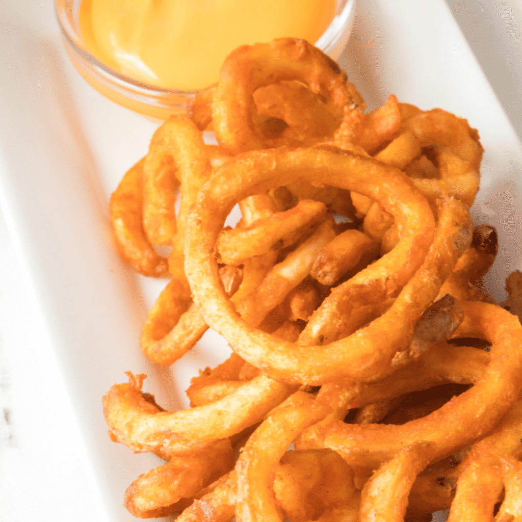 Air fryer Arby’s curly fries piled in a white serving bowl
