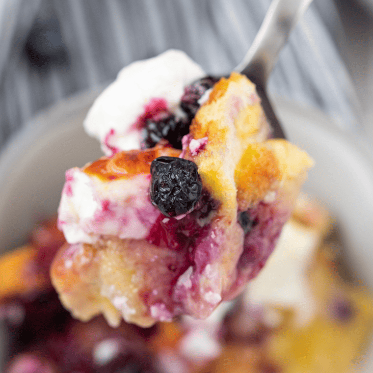 Bowl of air fryer blueberry French toast casserole with golden baked bread and fresh blueberries on top