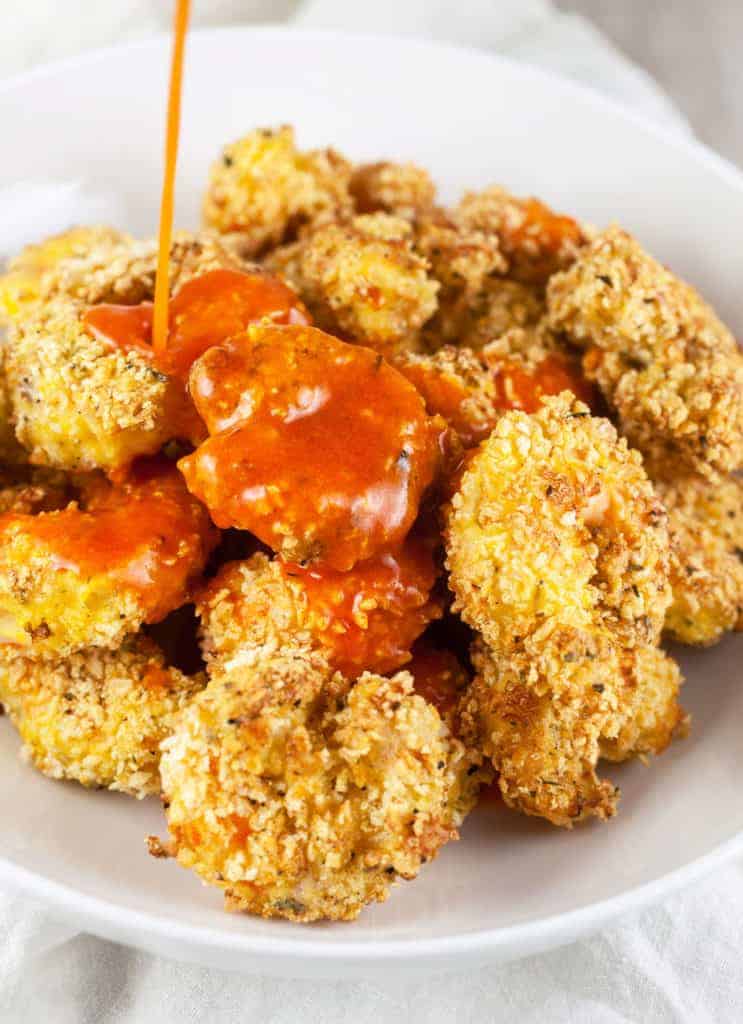 What temperature should I set my air fryer to for Buffalo Shrimp? Preheat your air fryer to 370 degrees F for Buffalo shrimp for 2-3 minutes. This high heat helps achieve a crispy exterior while ensuring the shrimp cook through. How long do I cook Buffalo shrimp in an air fryer? Cooking times can vary depending on the size of the shrimp and the specific air fryer model. As a general guideline, cook large shrimp (jumbo or extra-large) for about 8-10 minutes, flipping halfway through the cooking time. However, checking the shrimp for doneness and adjusting the cooking time accordingly is recommended. Use a meat thermometer and check the internal temperature in the thickest part of the shrimp; when the meat thermometer reads 145 degrees F, you can safely remove the shrimp from the air fryer basket. Can I use frozen shrimp for Buffalo shrimp in the air fryer? Yes, you can use frozen shrimp, but it's recommended to thaw them completely before cooking. Thawing the shrimp allows for even cooking and better adherence to the coating and sauce. What type of sauce can I use for Buffalo shrimp? Traditional Buffalo sauce combines hot sauce (such as Frank's RedHot) and melted butter. However, you can customize the sauce by adding additional ingredients like garlic powder, Worcestershire sauce, or vinegar to suit your taste preferences. How do I make the Buffalo shrimp less spicy? If you prefer milder heat, you can adjust the spiciness of the Buffalo shrimp by using a milder hot sauce or reducing the amount of hot sauce used in the sauce mixture. You can also add a bit of honey or brown sugar to balance out the heat. Can I use a different coating for the shrimp? Yes, you can experiment with different coatings. Besides flour or a mixture of flour and cornstarch, you can try using breadcrumbs (regular or panko), crushed cornflakes, or even a mixture of spices and crushed nuts for added texture and flavor. Can I make Buffalo shrimp without using any flour or coating? While a coating helps create a crispy texture, you can still achieve a similar flavor by tossing the cooked shrimp in Buffalo sauce directly, without any coating. However, note that the shrimp will have a different texture than the traditional crispy Buffalo shrimp. Can I reheat Buffalo shrimp in an air fryer? A: Yes, you can reheat Buffalo shrimp in the air fryer. Preheat the air fryer to 350°F (175°C), place the leftover shrimp in a single layer, and reheat for about 4-5 minutes until heated. Keep an eye on them to prevent overcooking. How to serve buffalo shrimp Appetizer: Buffalo shrimp makes a perfect appetizer. Serve them on a platter with toothpicks or skewers for easy grabbing. You can also add a side of celery sticks and carrot sticks for a classic Buffalo flavor combination. Salad: Create a Buffalo shrimp salad by adding the cooked and sauced shrimp to a bed of mixed greens or your favorite salad base. You can include toppings like cherry tomatoes, sliced cucumbers, crumbled blue cheese, sliced green onions, and a drizzle of ranch or blue cheese dressing. Sandwich/Wrap: Transform your Buffalo shrimp into a delicious sandwich or wrap. Use a soft roll, baguette, or corn tortilla, and layer the shrimp with lettuce, tomato, sliced onion, and a dollop of ranch or blue cheese dressing. It makes for a flavorful handheld meal. Tacos: Make Buffalo shrimp tacos by placing a few shrimp in a warmed tortilla. Top them with shredded cabbage or lettuce, diced tomatoes, chopped cilantro, and a drizzle of ranch or a squeeze of lime juice. Serve with a side of salsa or guacamole./ Rice or Pasta: Serve Buffalo shrimp over cooked rice or pasta for a heartier meal. Toss the shrimp with the sauce and serve it on a bed of fluffy rice or mix it into your favorite pasta dish. Add vegetables like bell peppers or peas for extra color and texture. Sliders: Mini Buffalo shrimp sliders are perfect for parties or gatherings. Place a few sauced shrimp on small slider buns or dinner rolls. Add some lettuce, tomato, and a touch of ranch or blue cheese dressing. Skewer them with toothpicks for easy handling.