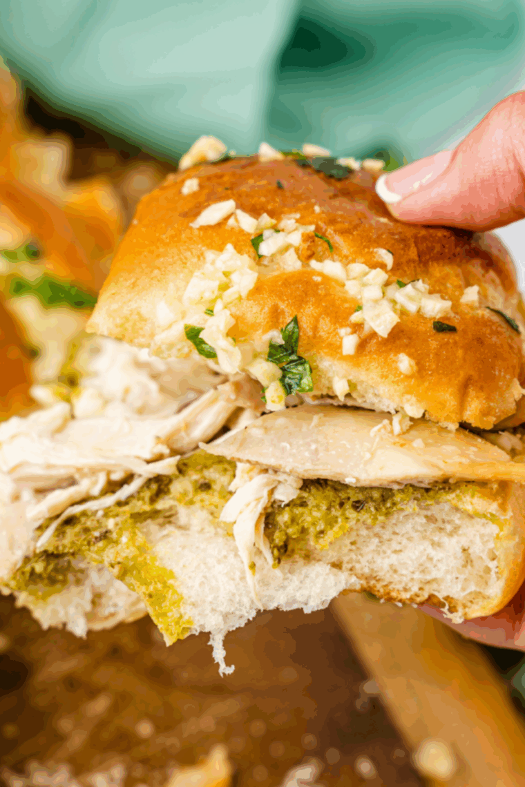A batch of pull-apart pesto chicken sliders topped with garlic butter inside an air fryer basket.