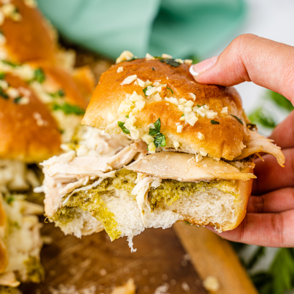 Golden brown, toasted chicken pesto sliders fresh out of the air fryer basket with melted cheese bubbling at the edges.