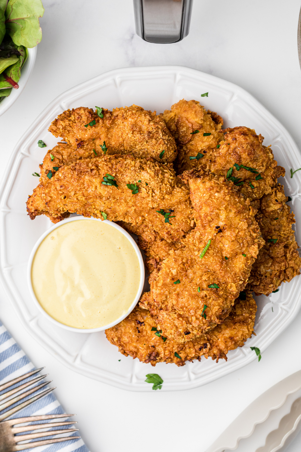 Homemade copycat Zaxby’s chicken fingers served with fries and dipping sauce.