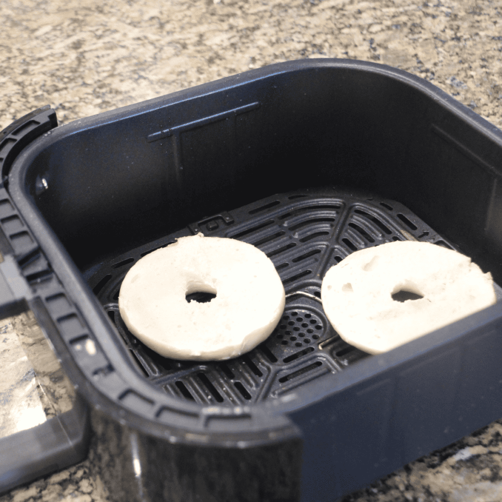 Lender’s bagels in an air fryer basket.