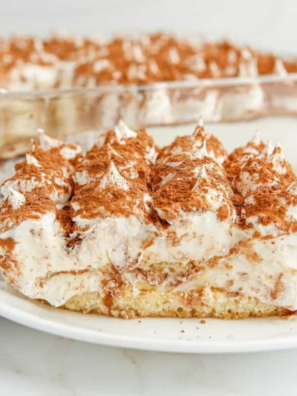 Slice of air fryer tiramisu on a white plate showing layers of espresso-soaked ladyfingers and mascarpone cream dusted with cocoa