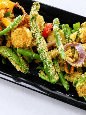 Plate of air fryer vegetable tempura with golden panko-crusted zucchini, sweet potato, and green beans beside a bowl of tentsuyu dipping sauce