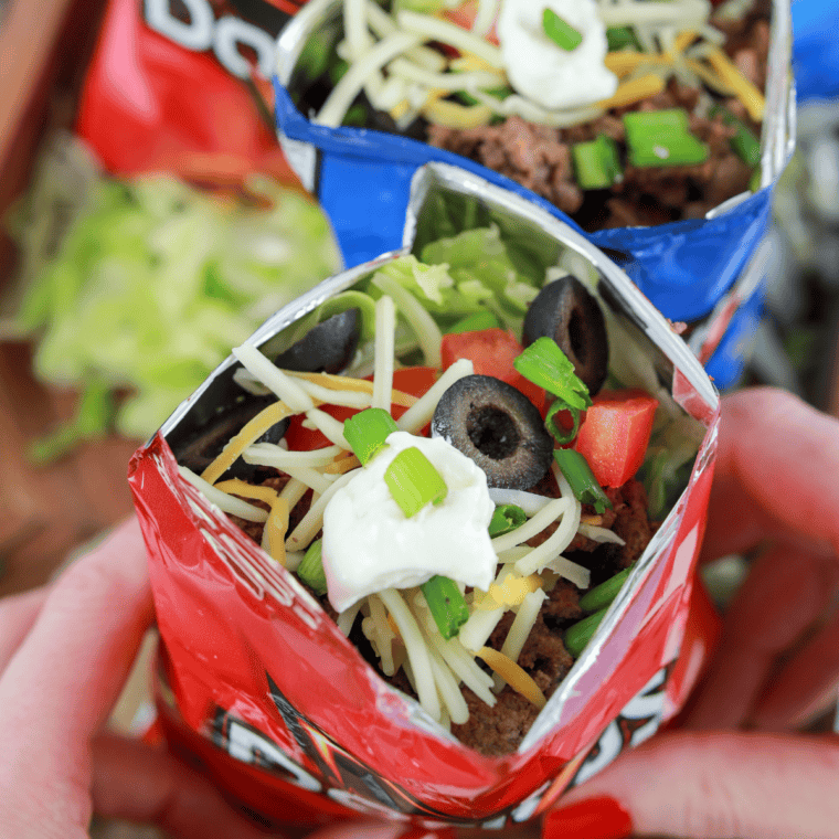 Air Fryer Walking Tacos served in a snack-sized chip bag, filled with seasoned meat, cheese, and fresh toppings.