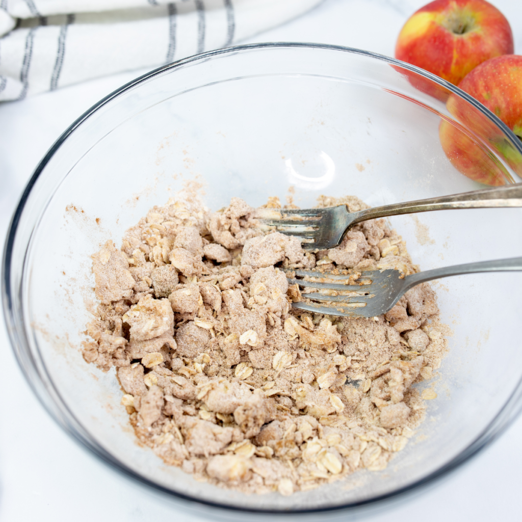 Sliced apples mixed with sugar, cinnamon, butter, lemon juice, and cornstarch in a bowl for Blackstone apple cobbler.