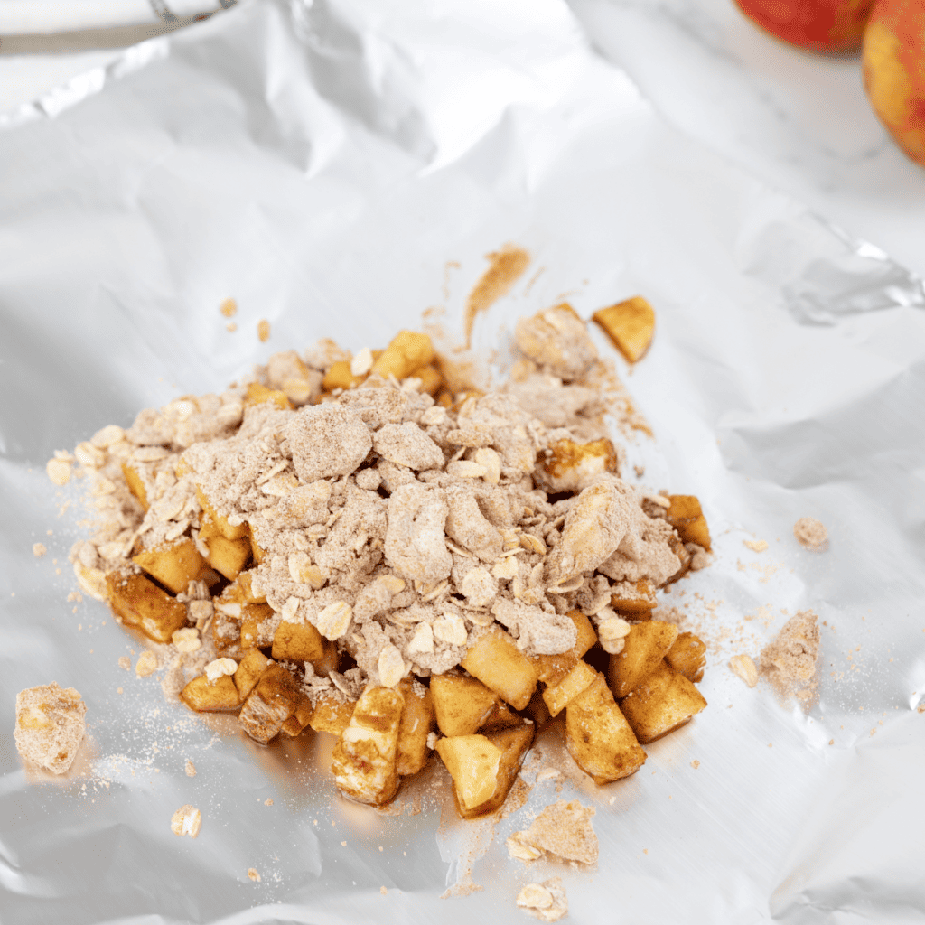 Apple cobbler filling cooking in a buttered skillet with cinnamon-spiced apples softening over medium heat.