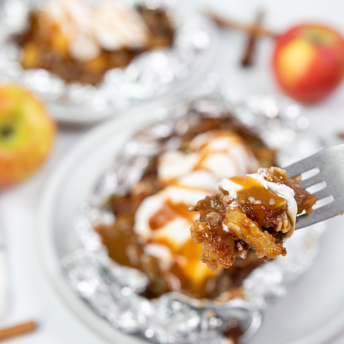 Blackstone apple cobbler in foil packets with cinnamon apples and crumb topping cooking on griddle.