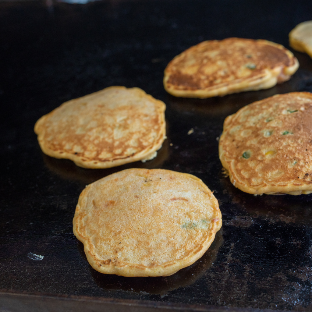 Corn kernels and sliced green onions folded into thick corn cake batter