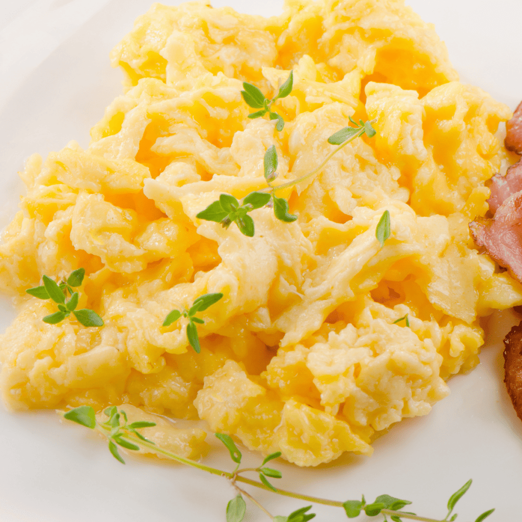 Folding scrambled eggs with a spatula on the Blackstone griddle for fluffy curds