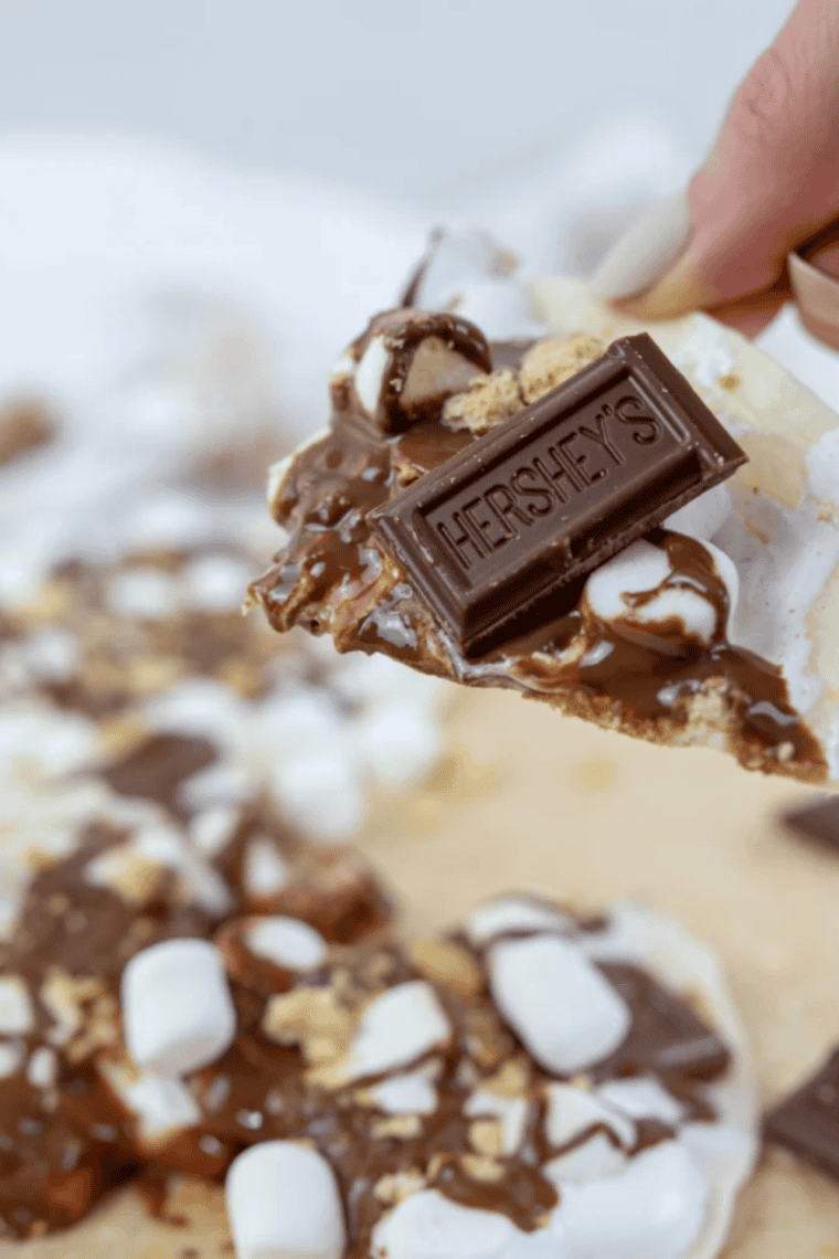 Easy Blackstone Grill s’mores pizza topped with melted chocolate, toasted marshmallows, and graham cracker pieces on a crispy crust